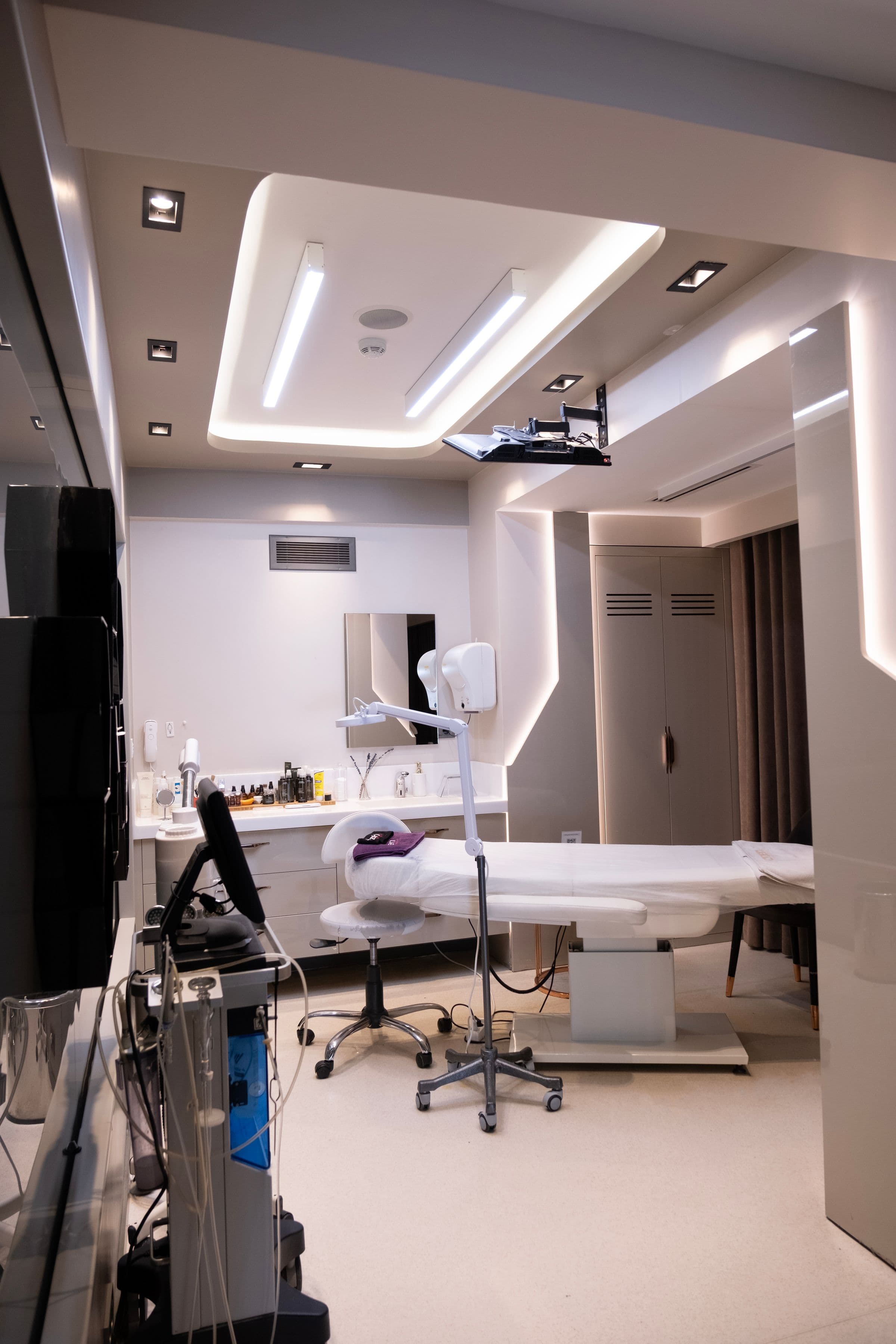 A treatment room with a reclining chair and ceiling lights