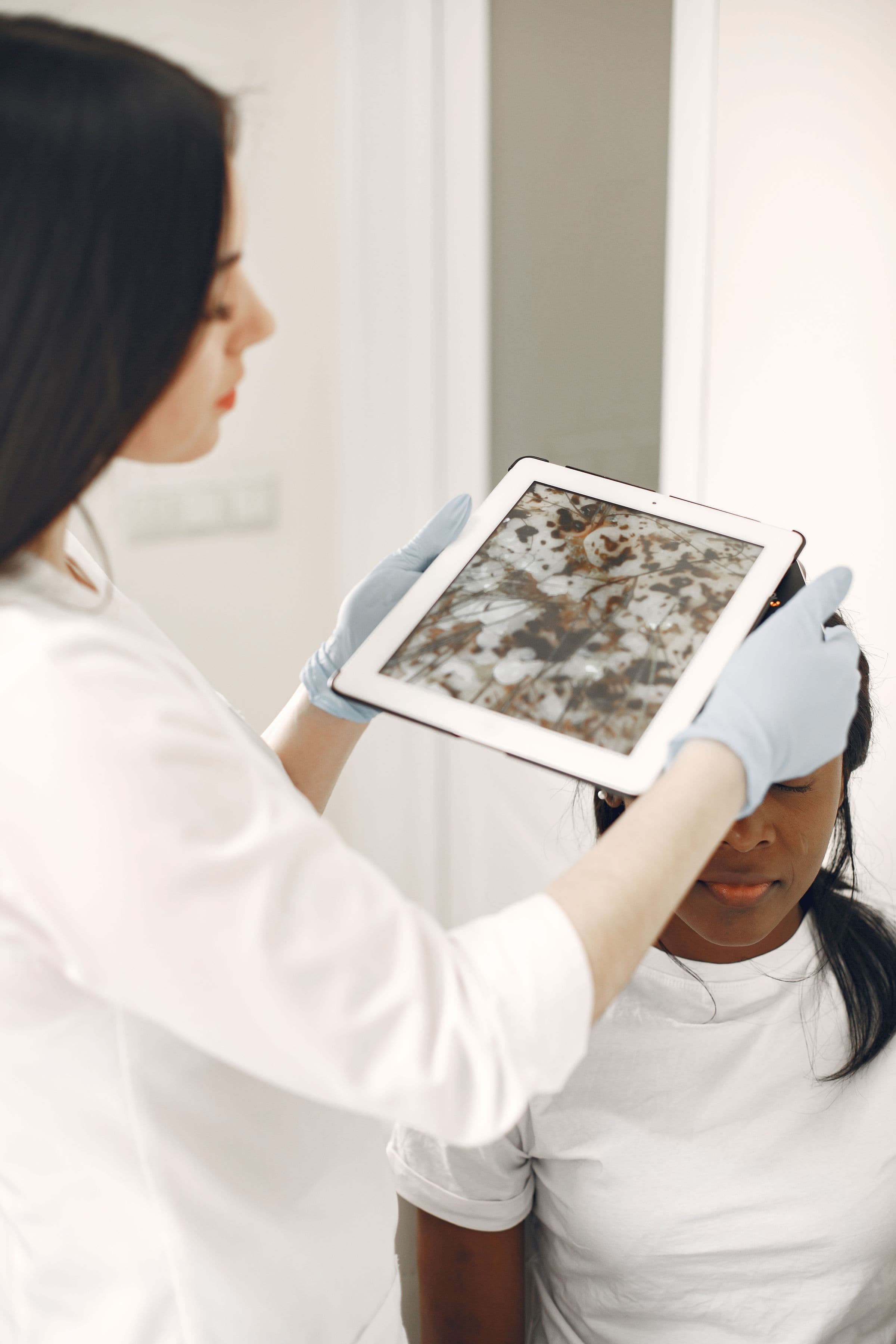 A physician reviewing a skin scan on a tablet